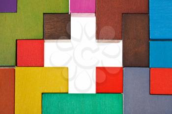 above view of cross shape hole in wooden multicoloured puzzle