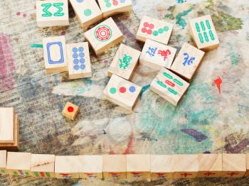 playing in mahjong game by wood tiles on shabby table closeup