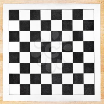 vinyl chessboard with black and white checks on wooden table