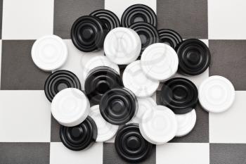 pile of checkers on black and white checkerboard