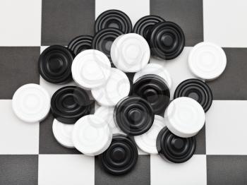 pile of draughts on black and white checkerboard