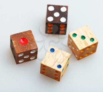 four wooden gambling dices on white table close up