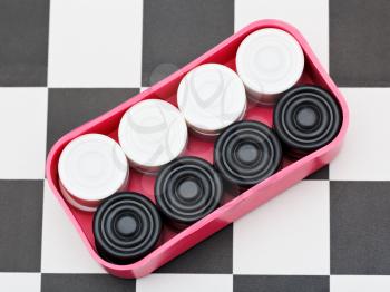 box with draughts on black and white checkerboard