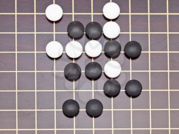 top view position of stones during go game playing on wooden goban