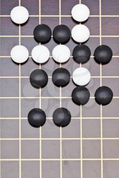 above view position of stones during go game playing on wooden goban