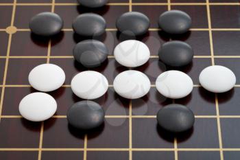 go game playing by stones on wooden goban
