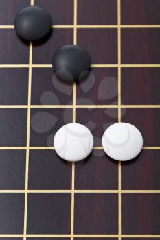 top view of few stones during go game playing on goban close up