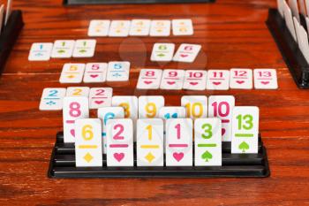 set of tiles in rack during playing in rummy game on wooden table