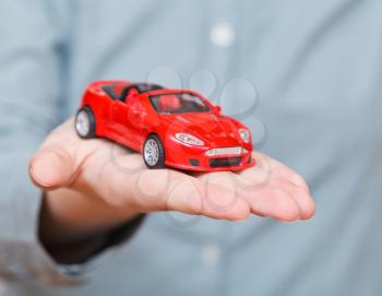 new red car on palm - hand gesture