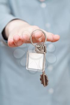blank key ring with door keys in hand close up
