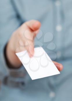 blank business card in between female fingers close up