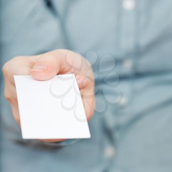 front view of blank business card in hand close up