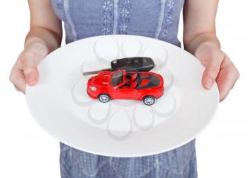 woman holds white plate with red car isolated on white background
