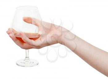 hand holds glass goblet with brandy isolated on white background