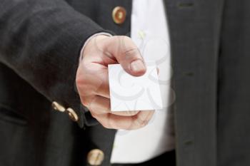 front view of blank white business card in businessman hand close up