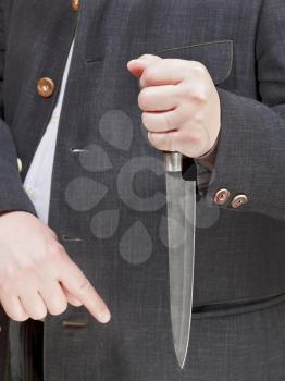 front view of large knife in businessman hand close up