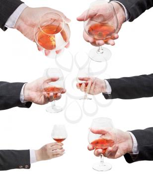 set of brandy glasses in businessman hand isolated on white background