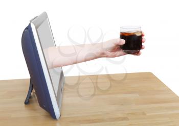 hand holding cola with ice in glass leans out TV screen isolated on white background