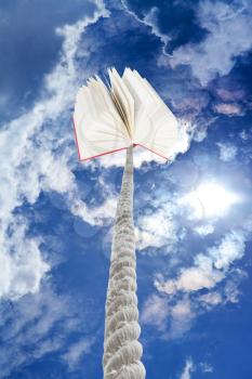book tied on rope soars into dark blue sky