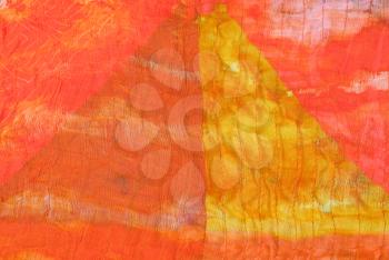 triangle geometrical pattern on stitched orange silk batik close up