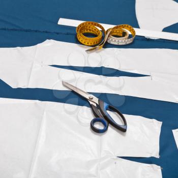 tailor tools and master forms of clothes on blue fabric for dress cutting