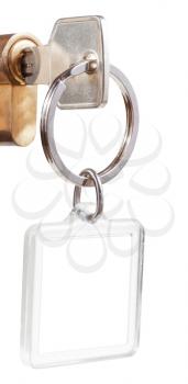 home key with cut out square keychain in cylinder lock close up isolated on white background