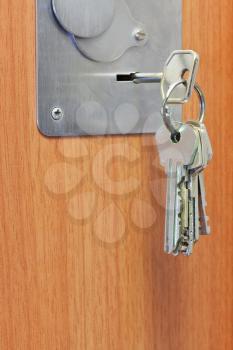 bunch of keys in keyhole of wooden door