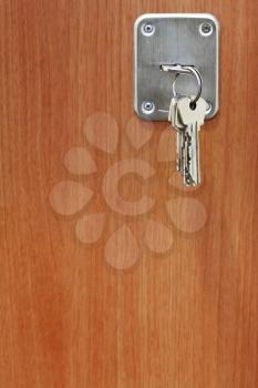 several keys in keyhole of wooden door