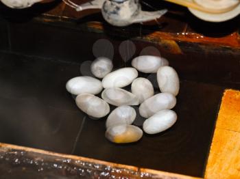Extracting raw silk fibre from cocoons on traditional Chinese factory