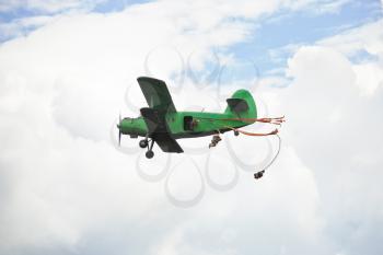 parachuting jump from small green aircraft in white clouds