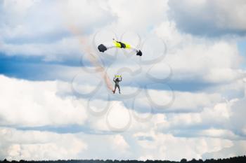 man landing after parachuting jump with cloudy sky background