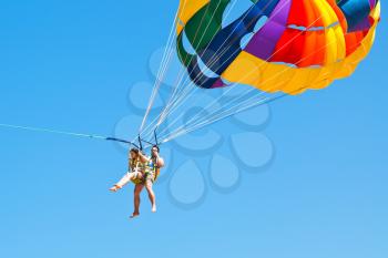 people parakiting on parachute in blue sky in summer day