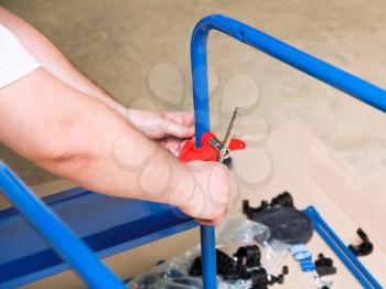 man assembles furniture by tools close up