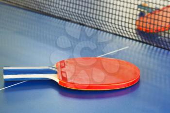 two red tennis racket on ping pong table close up