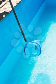 Cleaning of garden outdoor swimming pool by deep leaf rake