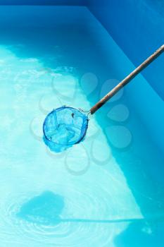 Cleaning of garden outdoor swimming pool by leaf net