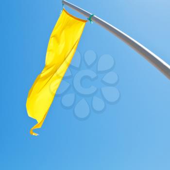 warning sign - yellow flag with blue sky background