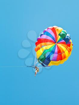 girl parakiting on parachute in blue sky in summer day
