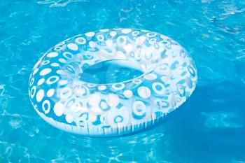 blue inflatable swimming circle in open air pool in summer day
