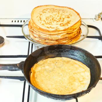 baked pancake in pan and stack of prepared pancakes