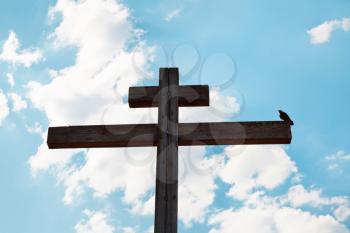 wooden orthodox cross, crow and blue sky background