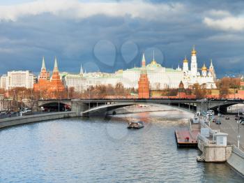 dark grey clouds over Moskva River and sunlight illuminates Moscow Kremlin in autumn day