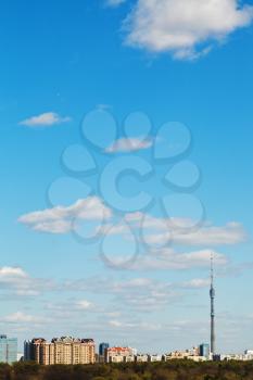 view of city with TV tower and urban park under blue sky in Moscow, Russia