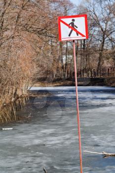 Do not walk sign on frozen river in spring day