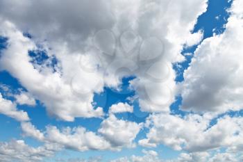 white and grey woolpack clouds in blue sky in summer day