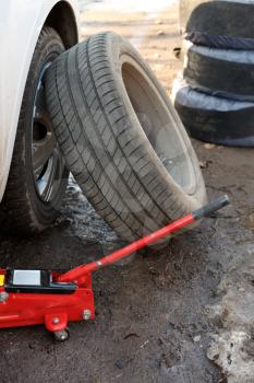 seasonal replacement of tires with jack outdoors - car tire fitting