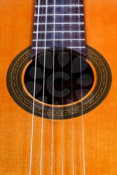 sound hole of classical acoustic guitar with six nylon strings close up