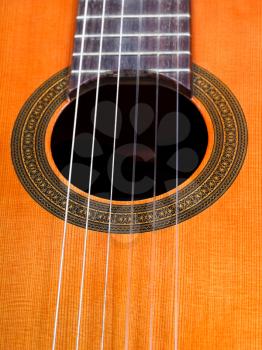 sound hole of spanish acoustic guitar with six nylon strings close up