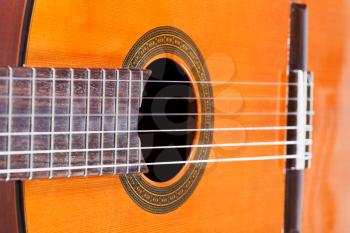 body of spanish acoustic guitar with six nylon strings close up
