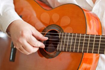 man playing classical acoustic guitar close up